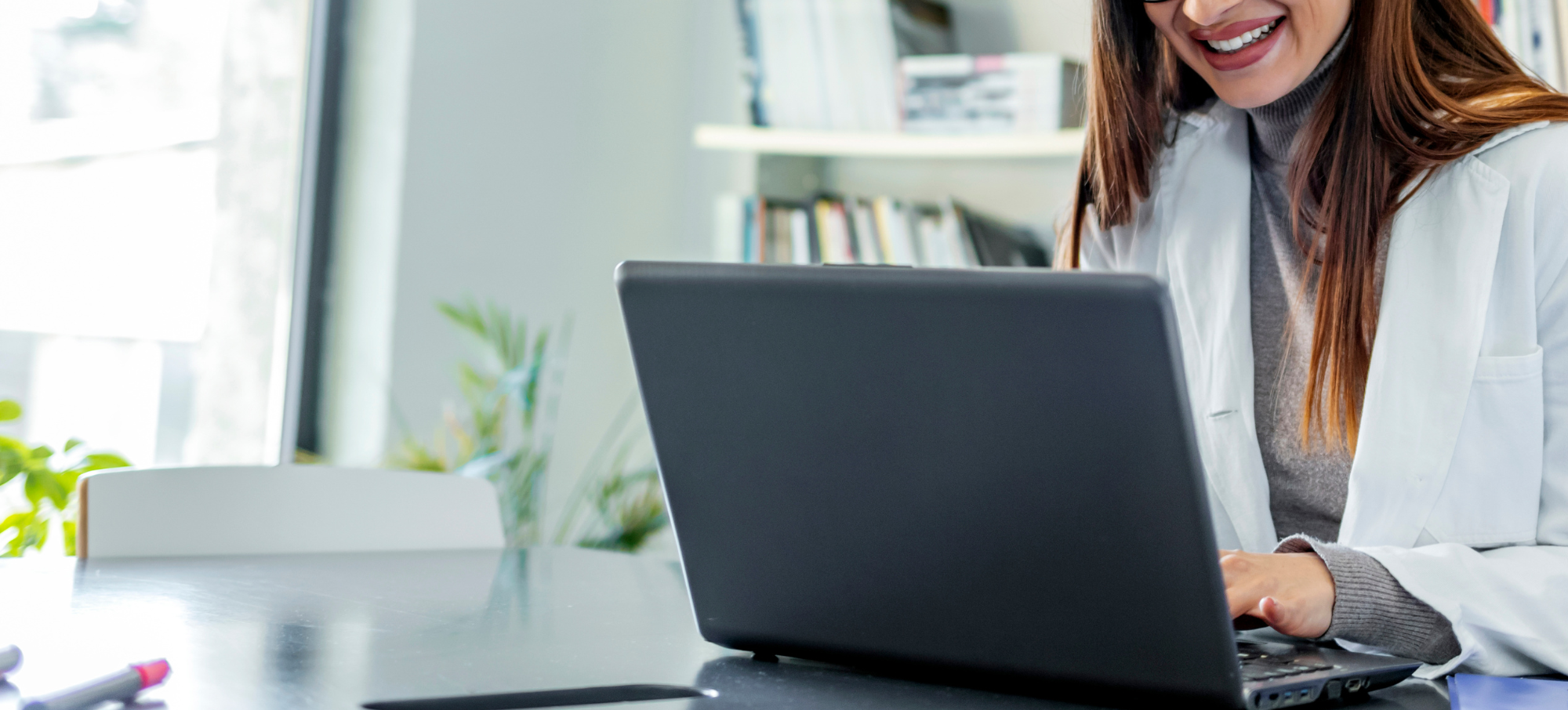 Female clinician on laptop using the Consultant Connect desktop calling feature