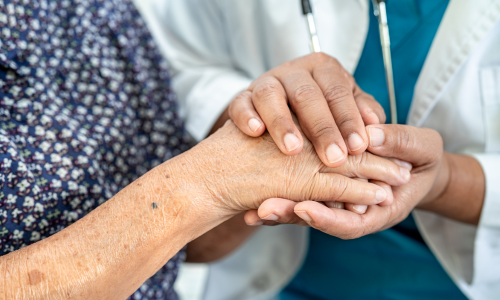 Clinician holding frailty patient's hand