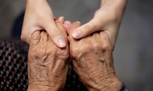 Female clinician holding frailty patient's hands